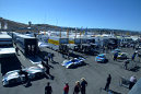 Race cars are pushed through the paddock area prior to the start of qualifying