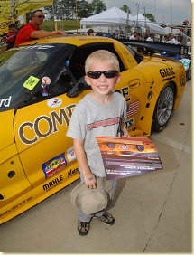 A young fan shows off the hero card he received from Corvette Racing
