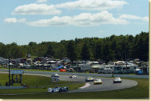 ALMS cars race past part of the large crowd